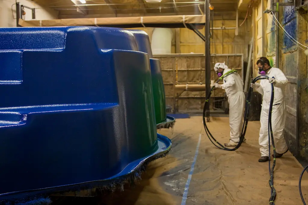 Workers spraying OEM manufacturers fiberglass pool