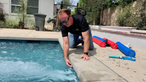 Pool and spa manufacturer reps test pool water to lower chlorine demand