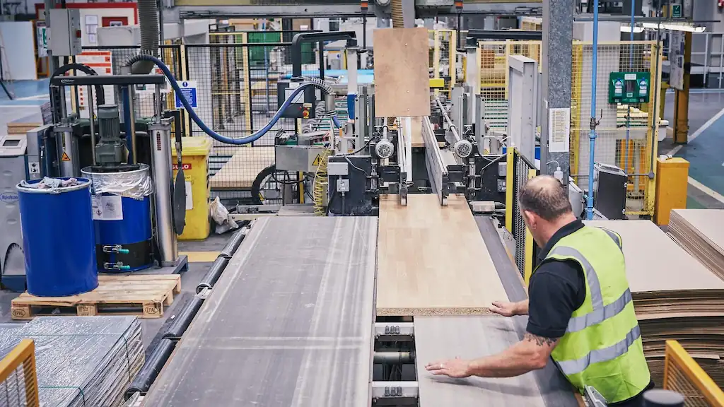 Man sawing wood in OEM manufacturers warehouse