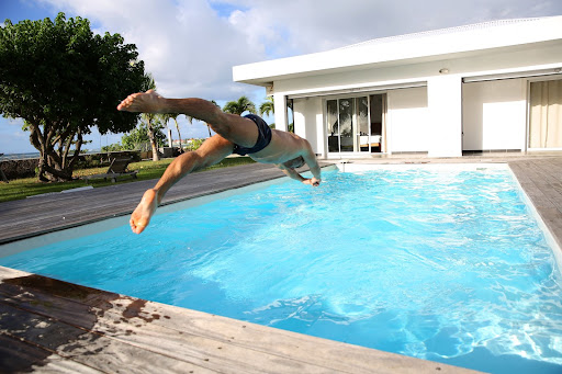 man diving into heated pool with pool heating